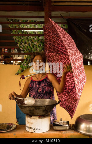 Alamby Philippines. 23 janvier, 2018. Une femme dans un centre d'évacuation utilise un parapluie pour protéger les aliments à partir de cendres volcaniques. Credit : Lewis Inman/Alamy Live News Banque D'Images