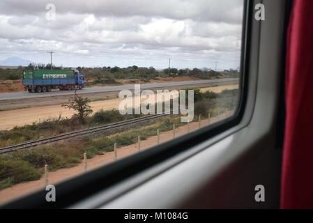 Le train de passagers de Mombasa à Nairobi le 13.08.2017 et la route de Nairobi avec les voies de l'ancien chemin de fer de l'Ouganda - Kenya. Dans le monde d'utilisation | Banque D'Images