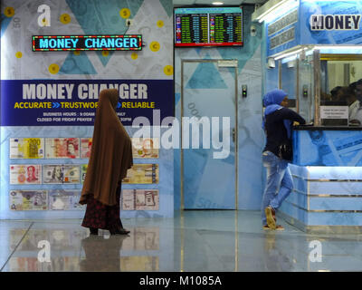 24 janvier 2018 - Kuala Lumpur, Kuala Lumpur, Malaisie - une femme est considéré à l'changeur de monnaie...Kuala Lumpur ou communément appelé KL est la capitale nationale de la Malaisie et est la plus forte croissance des régions métropolitaines en Asie du Sud-Est. L'urban city est également bien connu de l'organisation mondiale pour le tourisme et le shopping. Kuala Lumpur a un grand transport public pour les personnes dans la ville. (Crédit Image : © Faris Hadziq/SOPA via Zuma sur le fil) Banque D'Images
