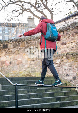 Grassmarket, Old Town, Édimbourg, Écosse, Royaume-Uni, 24 janvier 2018. Jeune homme équilibrant le parc sur la main courante dans les marches d'allée Banque D'Images