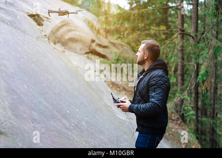 Guy démarre un quadrocopter dans la forêt Banque D'Images