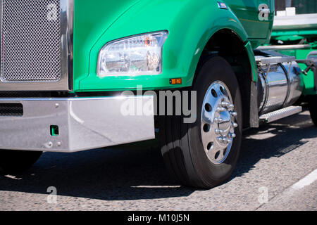 Détails avant de classic vert puissant gros camion semi truck avec calandre chromée se déplace le long de la route pour la livraison du fret commercial à temps Banque D'Images