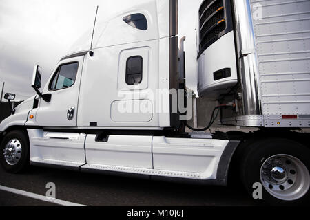 Bonnet blanc American big rig semi truck avec semi-remorque frigorifique et d'un réfrigérateur sur l'unité en marche sur la route le transport de produits périssables Banque D'Images