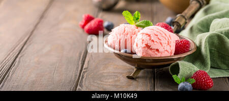 Glace à la framboise dans un bol en cuivre. Banque D'Images