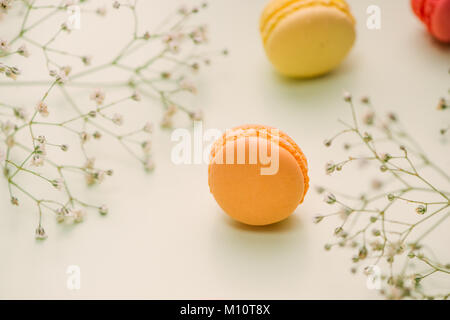 Matin cake macaron et fleur gypsophila sur fond vert clair à partir de ci-dessus. Petit déjeuner agréable. Mise à plat de style. Banque D'Images