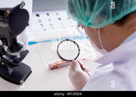 La police criminologue chemist looking at preuve du crime Banque D'Images
