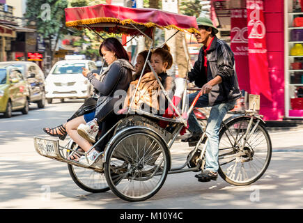 Les vélos-pousse, les vendeurs de rue et tours de Hanoï Vietnam vie Banque D'Images