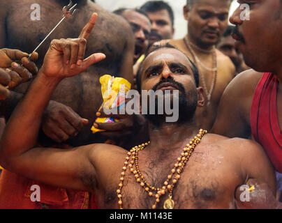 Singapour 2015 : passionnés d'Hindu obtenir percé dans leur bouche avec une aiguille et de transporter le lait pot pour le Seigneur Muruga lors des festival hindou Thaipusam Banque D'Images