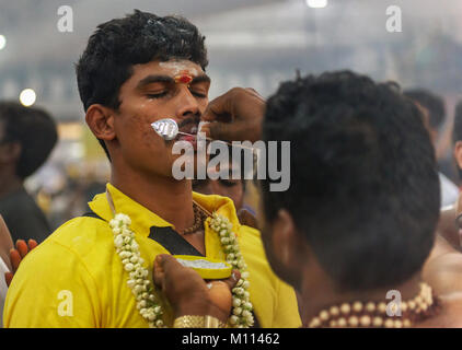 Singapour 2015 : passionnés d'Hindu obtenir percé dans leur bouche avec une aiguille et de transporter le lait pot pour le Seigneur Muruga lors des festival hindou Thaipusam Banque D'Images