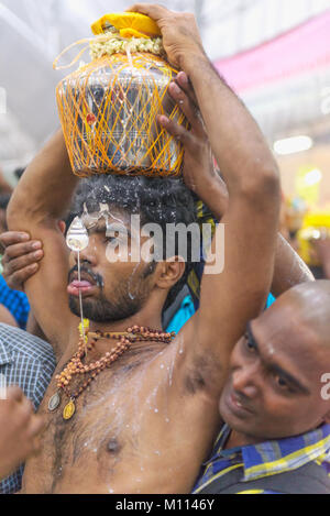 Singapour 2015 : passionnés d'Hindu obtenir percé dans leur bouche avec une aiguille et de transporter le lait pot pour le Seigneur Muruga lors des festival hindou Thaipusam Banque D'Images