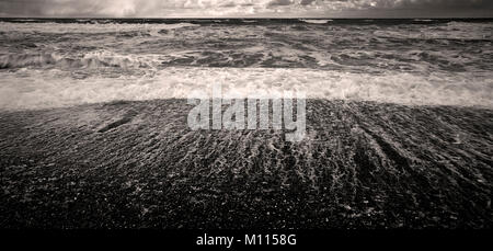 Vagues se brisant sur une plage de galets de mauvais temps Banque D'Images