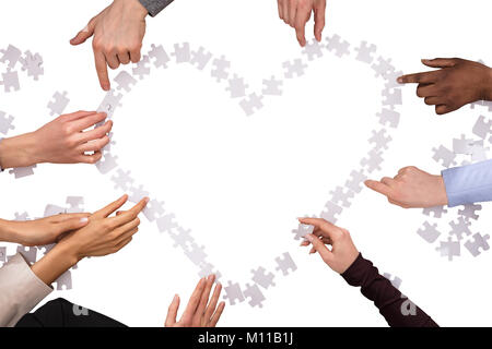 Groupe de mains en forme de coeur avec les casse-tête sur fond blanc Banque D'Images