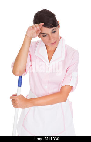 Portrait de jeune femme fatiguée Janitor Against White Background Banque D'Images