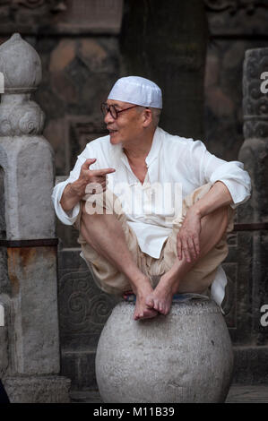 Xi'an, Chine - 5 août 2012, 2017 : Portrait d'un homme portant une taqiyah assis à une pierre, à la Grande Mosquée de Xi'an dans la ville de Xi'An en Chine, Banque D'Images