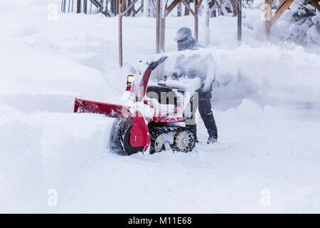 Hokkaido, Japon - 28 décembre 2017 - homme non identifié utiliser sa machine pour l'enlèvement de la neige rouge clair de façon à un parc à Hokkaido, Japon le 28 décembre Banque D'Images