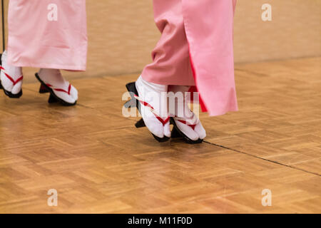 Voir des femmes japonaises les jambes et pieds en traditioanl traditioanl complète la danse de style japonais robe et chaussures geta, montrant avec style inhabituel de sta Banque D'Images