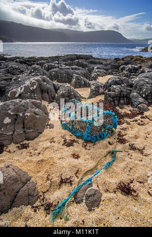 Casier à homard Homard / creel, faits de plastique non dégradables et nylon, échoués sur les rochers en Ecosse, Royaume-Uni Banque D'Images