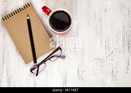 Ordinateur portable, crayon, verres et une tasse de café sur une table en bois blanc Banque D'Images