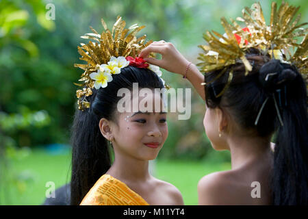 L'Indonésie. Sambirenteng. Île de Bali. Les jeunes danseurs de Bali traditionnel (femelle) la préparation des coiffes. Banque D'Images