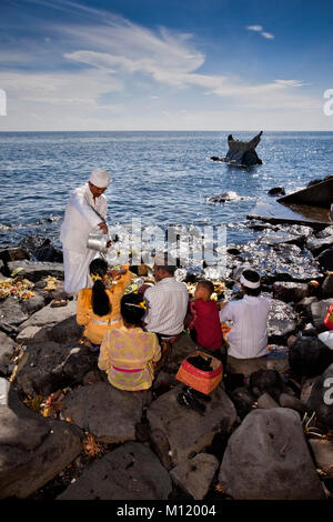 L'île de Bali, Indonésie, Alassari, Sea temple appelé Pura Batu Ponjok. Melasti Festival pour honorer les dieux de la mer. Famille et prêtre à l'épargne. Banque D'Images