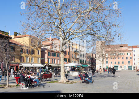 Campo Santa Margherita, Dorsoduro, Venise, Vénétie, Italie à l'heure du midi en hiver. Populaire auprès des habitants et les étudiants, les gens mangent sur des bancs et Banque D'Images