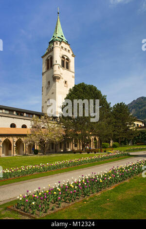 Parc de la ville de printemps, avec des lits de tulipes à fleurs,à l'arrière-plan le clocher de l'église paroissiale Maria Himmelfahrt,Schwaz Banque D'Images