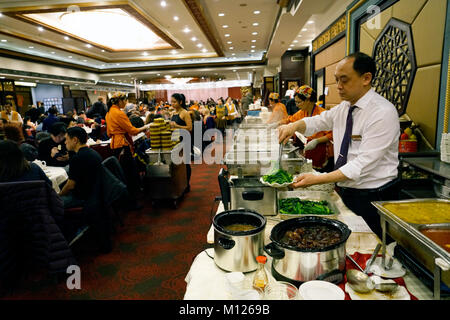 Un garçon chinois préparer la nourriture au buffet table dans toujours bondé Jing Fong restaurant chinois dans Chinatown.Manhattan.New York City.USA Banque D'Images