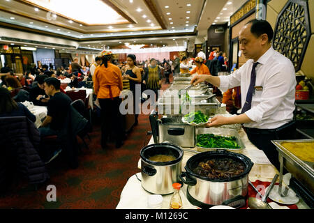 Un garçon chinois préparer la nourriture au buffet table dans toujours bondé Jing Fong restaurant chinois dans Chinatown.Manhattan.New York City.USA Banque D'Images