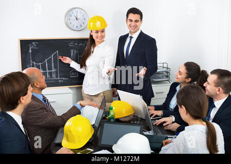 Sourire énergique réussie avec des ordinateurs portables professionnels et des casques ayant réunion de travail Banque D'Images