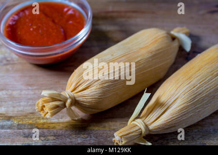 Deux tamales sur table en bois servi avec sauce à base de tomate chaude- nourriture Mexicaine Banque D'Images