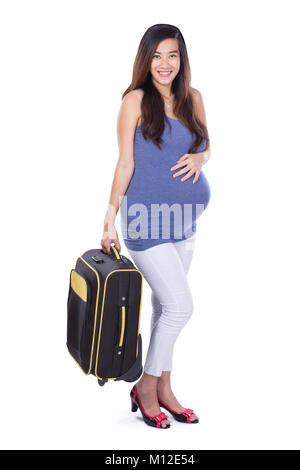 Un portrait d'une femme enceinte asiatique apportent une valise à fond blanc. Prêt pour le voyage Banque D'Images