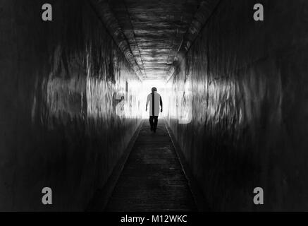 Silhouette d'un homme marchant à l'intérieur d'un tunnel sombre à l'intérieur jusqu'au fort d'Amber, Inde Banque D'Images