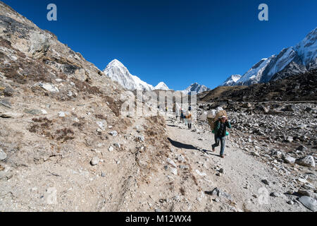 Porteurs Sherpa et trekkers juste avant d'arriver à Gorak Shep, Népal Banque D'Images