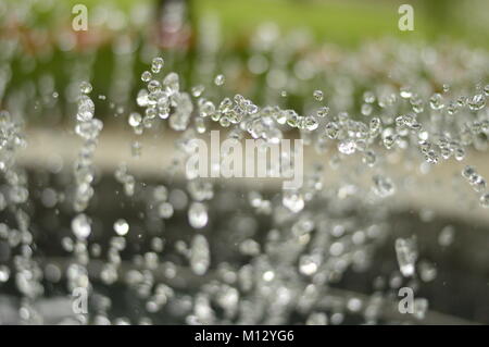 Les petites gouttes d'eau brillantes et d'une fontaine Banque D'Images