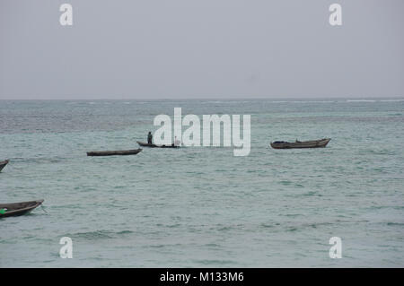 Aller en mer des pêcheurs en bateaux dhow traditionnel à Nungwi sur l'île de Zanzibar et ses eaux turquoises de l'Océan Indien Banque D'Images