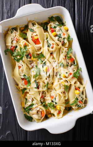 À partir de la casserole de pâtes conchiglioni farcis au poulet, champignons et légumes close-up dans un plat allant au four, sur une table. Haut Vertical Vue de dessus Banque D'Images