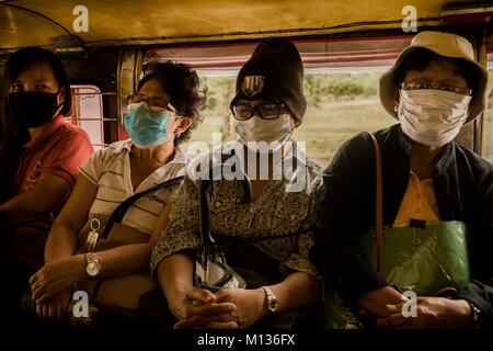 Bicol, Philippines. 25 janvier, 2018. Un groupe de femmes sur un Jeepney bus avec masque de visage pour les protéger des cendres du volcan Mayon. Credit : Lewis Inman/Alamy Live News Banque D'Images