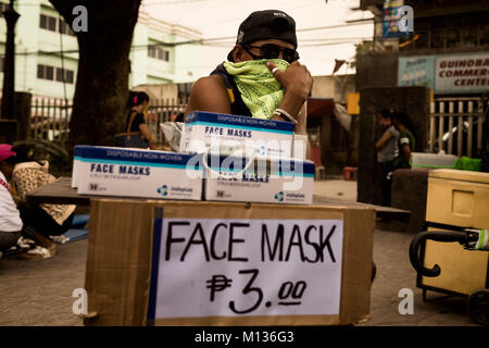 Bicol, Philippines. 25 janvier, 2018. Un homme vend des masques pour les personnes évacuées de l'erruption du volcan Mayon. Credit : Lewis Inman/Alamy Live News Banque D'Images