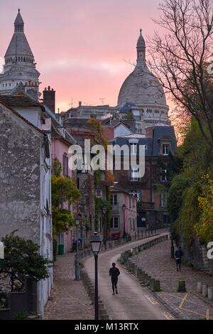 France, Paris, Paris, un homme s'exécute sur l'Abreuvoir à Montmartre Rue au lever du soleil Banque D'Images