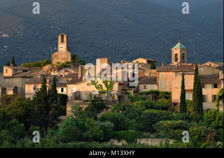 La France, Vaucluse, Le Parc Naturel Régional du Luberon (Parc Naturel Régional du Luberon), Lourmarin, étiqueté Les Plus Beaux Villages de France (Les Plus Beaux Villages de France), la tour de l'horloge et le clocher de l'église, le massif du Luberon en arrière-plan Banque D'Images