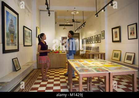 Le Cambodge, Battambang, artiste plastique discutant avec une jeune femme dans sa galerie de peinture Banque D'Images