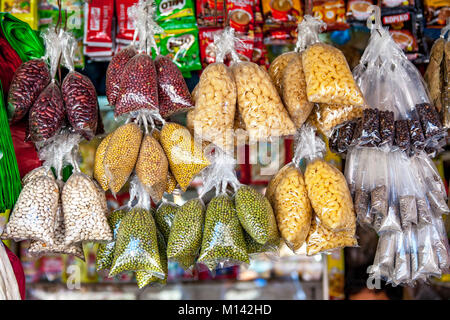 Des sacs en plastique remplis d'une variété colorée des pois, des haricots, des pâtes et des épices se bloquer dans la fonction d'interrogation à Barretto, Luzon, Philippines. Banque D'Images