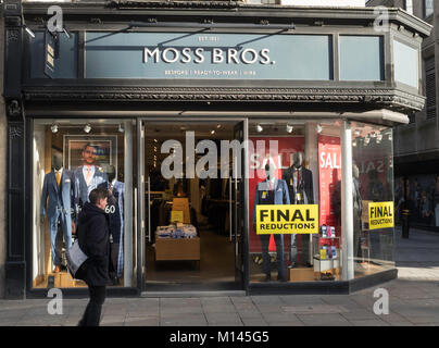 Homme marchant passé la boutique avant de Moss Bros., Newcastle upon Tyne, England, UK Banque D'Images