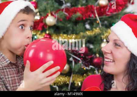 Mère Fils pour gonfler des ballons à la nuit de Noël Banque D'Images
