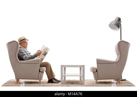 Homme mûr assis dans un fauteuil lisant un journal isolé sur fond blanc Banque D'Images