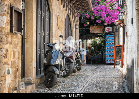 RHODES, GRÈCE - AOÛT 2017 : moto garée à rue étroite près de café grec de la ville de Rhodes, sur l'île de Rhodes, Grèce Banque D'Images