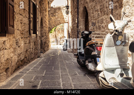 RHODES, GRÈCE - AOÛT 2017 : moto garée à rue étroite près de café grec de la ville de Rhodes, sur l'île de Rhodes, Grèce Banque D'Images