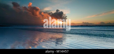 Les nuages orageux avec les rayons du soleil juste avant le coucher du soleil en hivers un jour à la tête de l'Ouest West Wittering sur Beach Banque D'Images