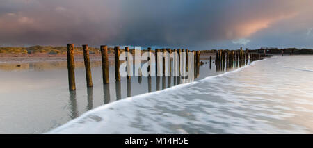 Les nuages orageux avec les rayons du soleil juste avant le coucher du soleil en hivers un jour à la tête de l'Ouest West Wittering sur Beach Banque D'Images