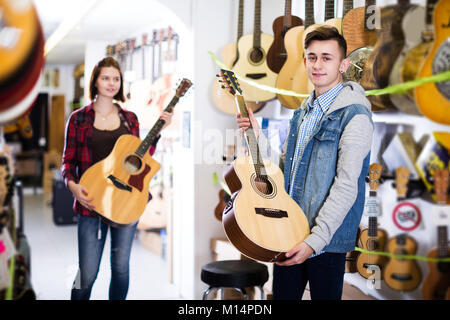 Garçon et fille positive choix optimal en guitare acoustique Guitare shop Banque D'Images
